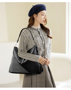 Detailed view of a black and white hobo bag with sparkling rhinestones worn by a model