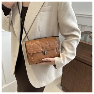 Vue détaillée du sac en cuir matelassé marron avec chaîne sombre et fermoir vertical
