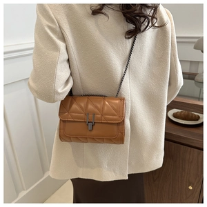 Vue détaillée du sac matelassé marron avec bandoulière chaîne et fermoir pivotant chic