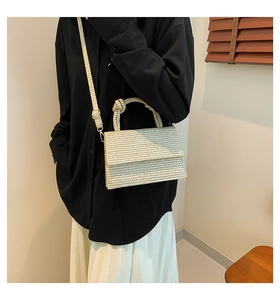 Detail of light beige woven texture crossbody bag with unique knot handle design