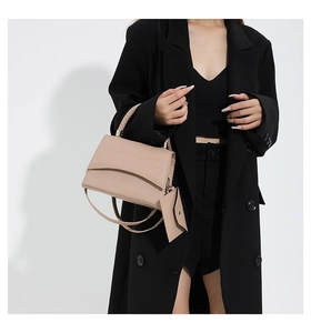 Détail du sac à main beige motif crocodile avec poignée tressée et mini pochette assortie