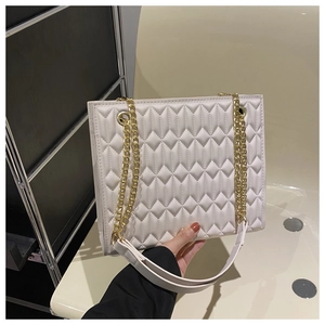 Detail of off-white quilted crossbody bag with golden chain straps and embossed rhombic pattern