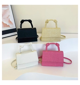 Close-up of four mini woven flap crossbody bags in black, gold, cream and rose pink