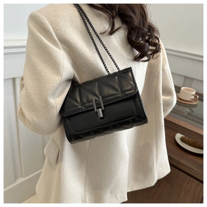 Détail du sac bandoulière noir matelassé avec boucle en métal et cuir brillant