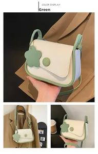 Dettagli della borsa a tracolla verde e crema con ciondolo a fiore e chiusura elegante
