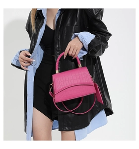Détail du sac à main rose crocodile avec poignée tressée et fermoir métallique chic