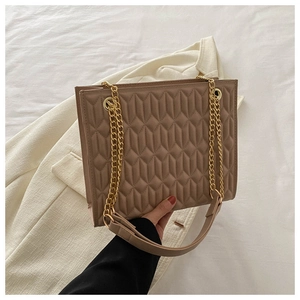 Detail of khaki quilted faux leather tote bag with gold chain and wide shoulder strap
