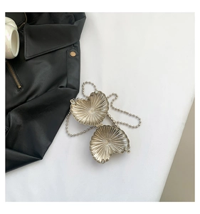 Macro view of heart-shaped silver metallic mini bag with radiant textured surface