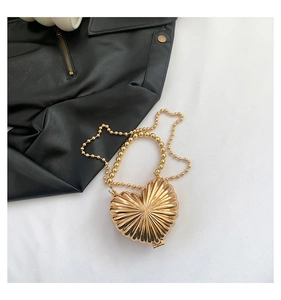 Top-down view of a golden heart-shaped mini bag with radiant texture and gold bead chain