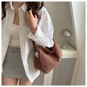 Close-up of caramel corduroy hobo bag texture with cute cloud pendant on a model