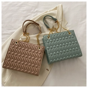 Close-up of quilted chain bags in brown and green with detailed diamond texture