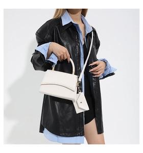 Sac à main blanc motif crocodile avec mini pochette porté par un mannequin en chemise
