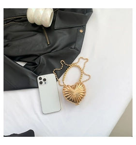 Detailed view of a mini gold heart-shaped evening bag with a beaded chain strap