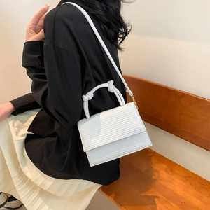 White woven texture square crossbody bag with thick knot handle worn by a model