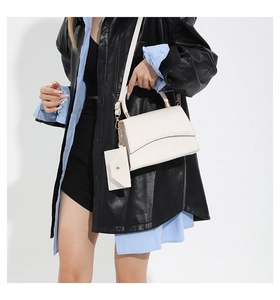 Vue détaillée du sac à main blanc motif crocodile avec poignée tressée et pochette enveloppe