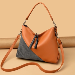 Close-up of caramel brown pebble leather crossbody bag with sparkling rhinestone patchwork