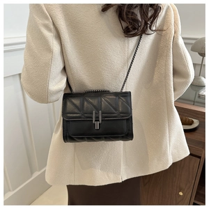 Détail du sac bandoulière matelassé noir avec fermoir métallique élégant et texture en cuir