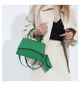 Sac à main vert texture crocodile avec poignée tressée et mini pochette assortie