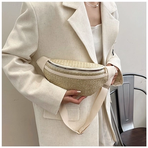Détail d'un sac bandoulière en paille tressée avec garniture en cuir et fermeture argent