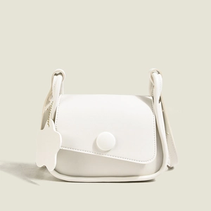 Borsa a tracolla in pelle bianca minimalista con patta asimmetrica e ciondolo floreale