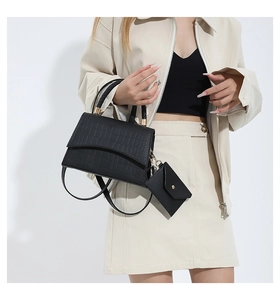 Détail de l'ensemble sac à main noir motif crocodile avec mini pochette et dorures