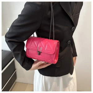 Détail du sac à chaîne matelassé rouge rose montrant la texture et le fermoir sur un modèle