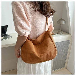 Detailed texture of caramel corduroy crescent bag showing large capacity and soft material