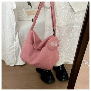 Pink corduroy crossbody bag featuring a matching round detachable coin purse detail