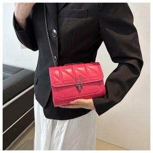 Détail d'un sac bandoulière matelassé rouge rose avec chaîne et boucle en métal