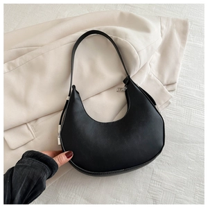 Detail of a black matte leather crescent underarm bag with silver zipper and shoulder strap