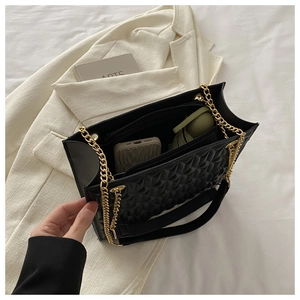 Detail view of large quilted tote bag with chain strap and spacious interior compartment