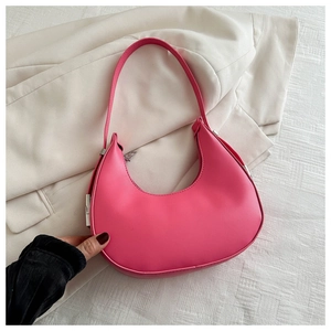 Detail of rose pink crescent hobo bag in smooth PU leather on a beige blazer