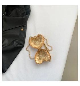 Golden heart shaped metal mini bag featuring radial texture and fine bead chain strap