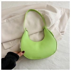 Detailed close-up of lime green crescent shoulder bag on minimalist neutral background