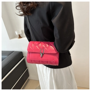 Détail du sac bandoulière matelassé rose avec chaîne en métal porté par un mannequin
