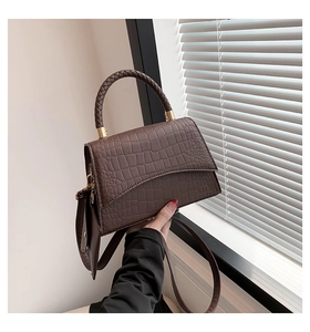 Vue détaillée du sac à main marron foncé effet crocodile avec poignée tressée et dorures
