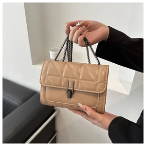 Détail du sac bandoulière matelassé abricot avec chaîne en métal et fermoir rotatif