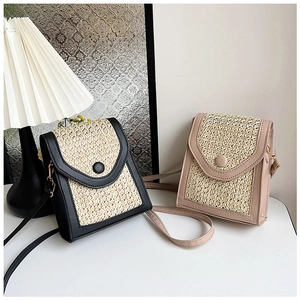 Detailed close-up of woven straw and PU leather crossbody bags in black and beige