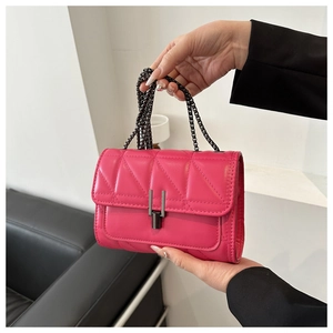 Détail du sac bandoulière matelassé fuchsia avec fermoir métal et bandoulière chaîne