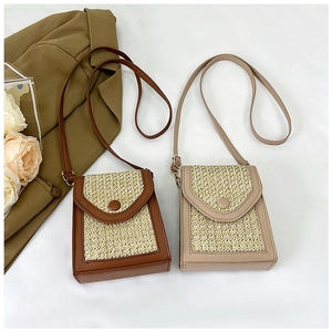 Flat lay of vintage woven straw crossbody bags in brown and beige with leather trim