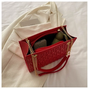 Detail showing the spacious interior multi-layer storage of the red geometric chain bag