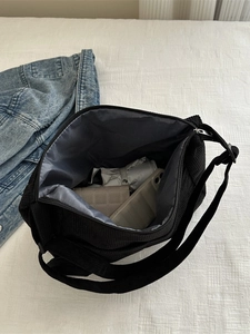 Minimalist black corduroy crossbody bag with internal storage for phone and wallet