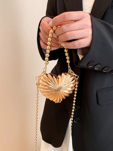 Golden heart-shaped metal evening bag with shell texture and beaded chain strap