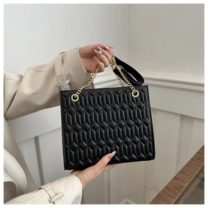 Close-up of black PU leather chain bag with quilted pattern and gold metal hardware