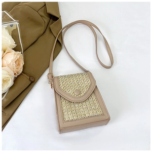 Detail of straw and beige leather crossbody bag with snap button closure and shoulder strap