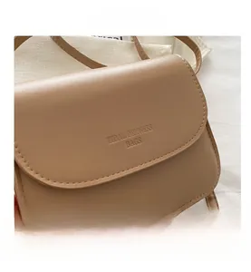 Nahaufnahme einer hellbraunen matten PU-Leder Umhängetasche mit dezentem Logo-Detail
