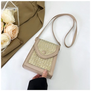 Detail of beige straw woven crossbody bag featuring PU leather trim and flap closure