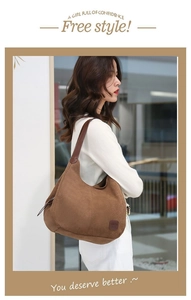 Vue latérale du grand sac hobo en daim marron avec détail zippé porté par un mannequin