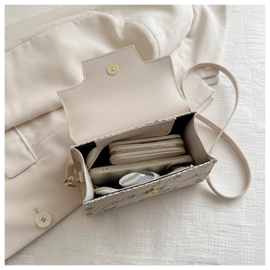 Detail of woven handbag interior showing magnetic gold clasp and daily storage capacity