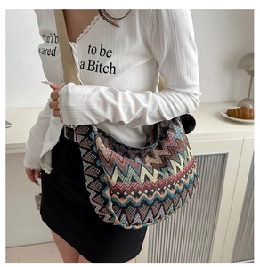 Detail der Bohème-Stricktasche mit Zickzackmuster, beigem Gurt und schwarzem Pompon